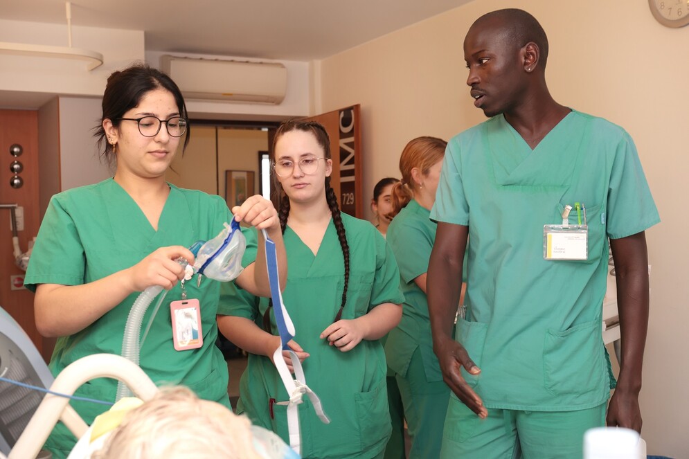 Drei Pflege-Auszubildenden im Patientenzimmer